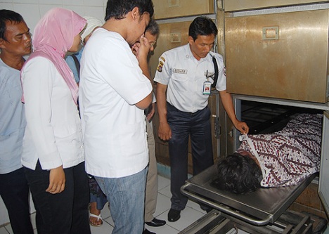 Petugas keamanan memperlihatkan jasad Anggi kepada anggota keluarga di kamar jenazah RSUP dr M Djamil, Selasa (16/6).